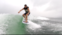 a man wakesufing on lake arenal in a rainy morning
 - Costa Rica